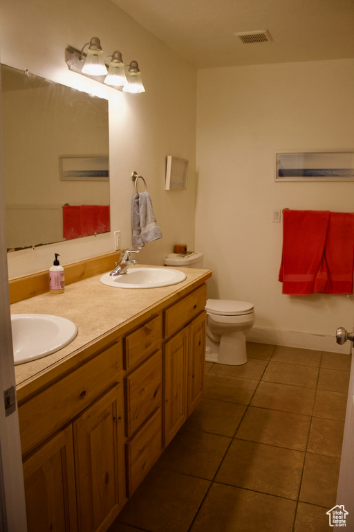 Bathroom featuring tile patterned floors, vanity, and toilet