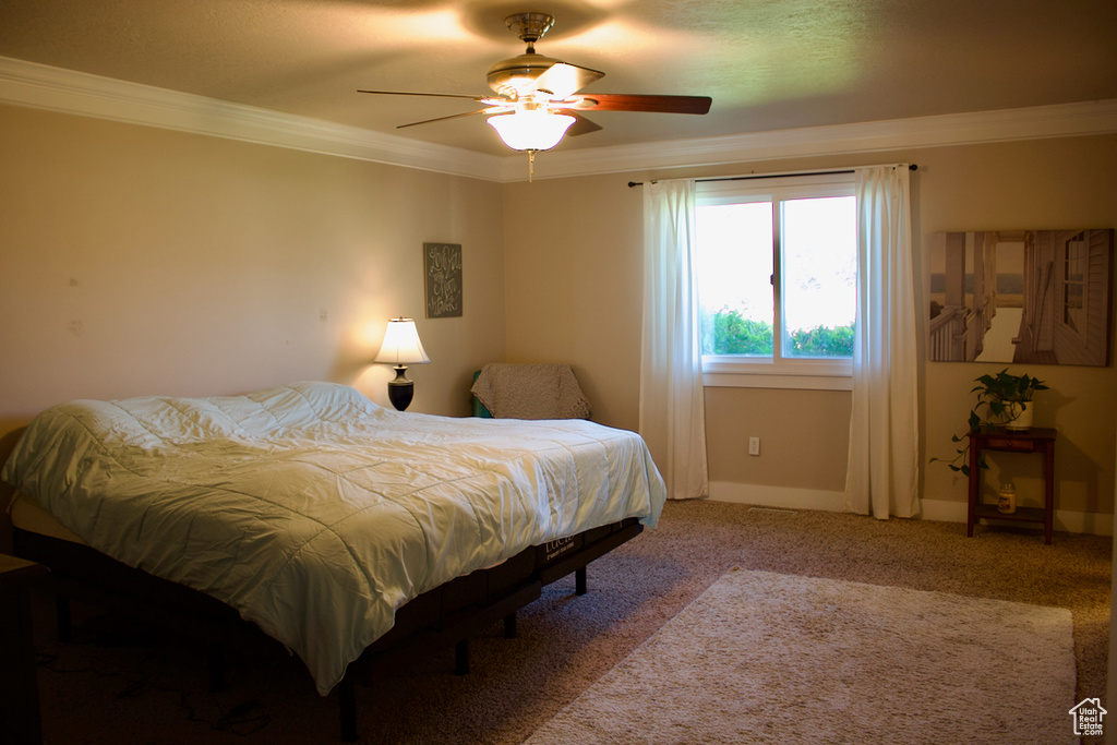 Bedroom featuring ceiling fan, light colored carpet, and crown molding