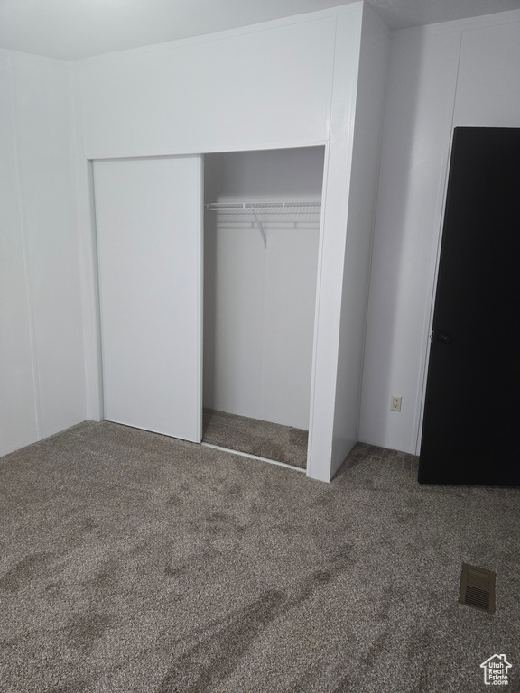 Unfurnished bedroom featuring carpet floors and a closet