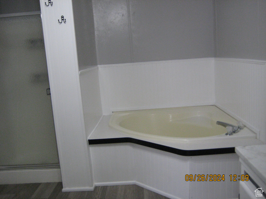 Bathroom with vanity, separate shower and tub, and hardwood / wood-style flooring