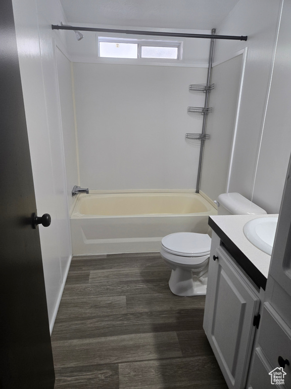 Full bathroom with wood-type flooring, vanity, bathtub / shower combination, and toilet