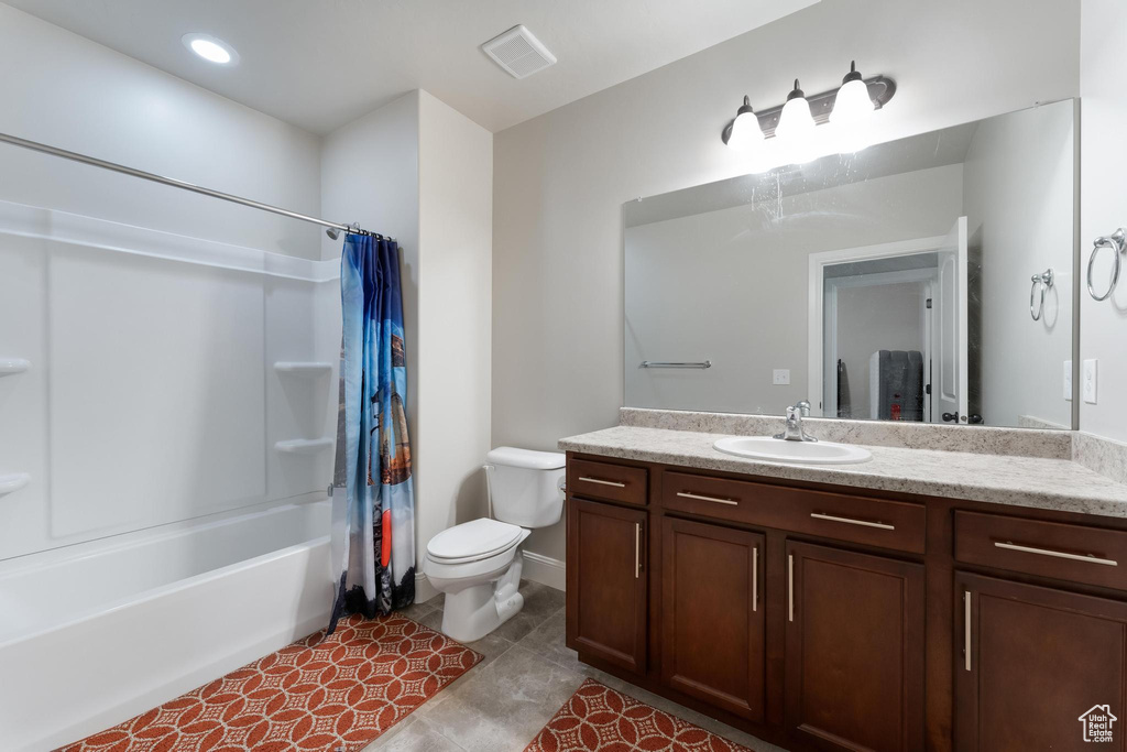 Full bathroom with shower / tub combo with curtain, vanity, toilet, and tile patterned floors