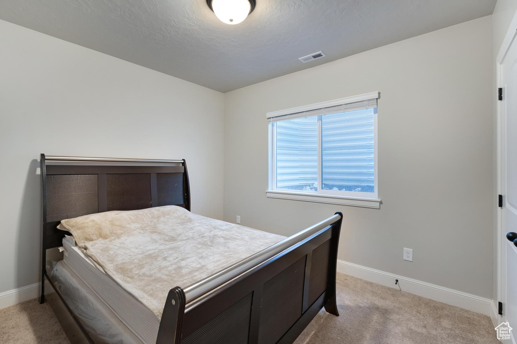 Carpeted bedroom featuring a textured ceiling