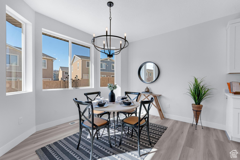 Dining room featuring light wood-type flooring and an inviting chandelier