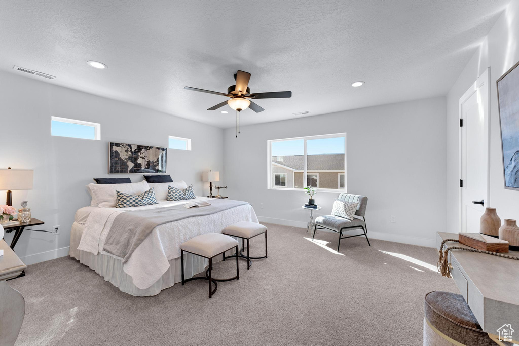 Carpeted bedroom featuring a textured ceiling and ceiling fan