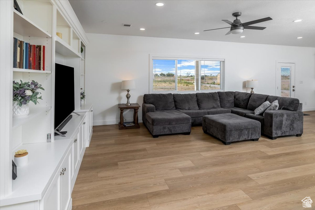 Living room with light wood-type flooring and ceiling fan