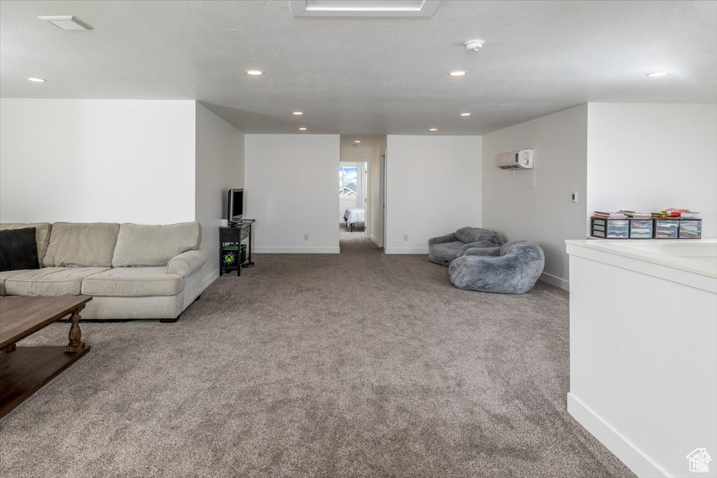 Living room with light carpet and an AC wall unit