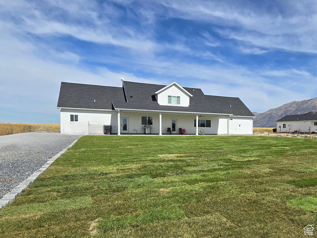 View of front facade featuring a front lawn, central air condition unit, and a mountain view