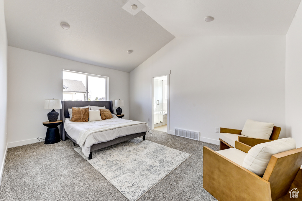 Carpeted bedroom featuring connected bathroom and vaulted ceiling