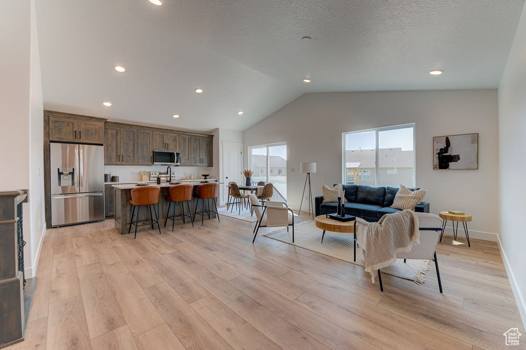 Living room featuring light hardwood / wood-style floors and vaulted ceiling