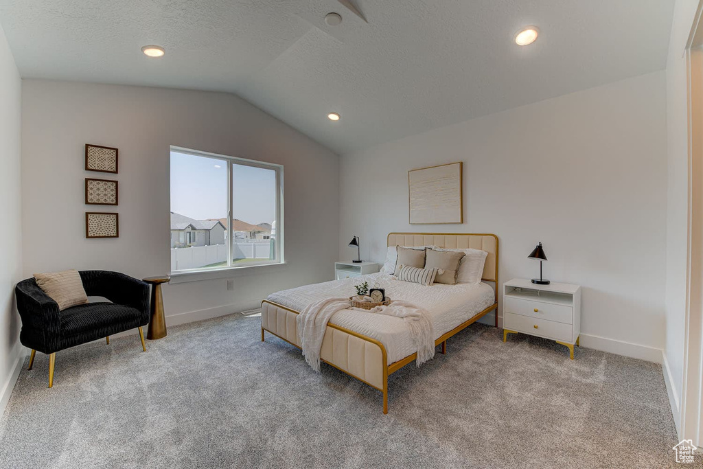 Carpeted bedroom featuring vaulted ceiling