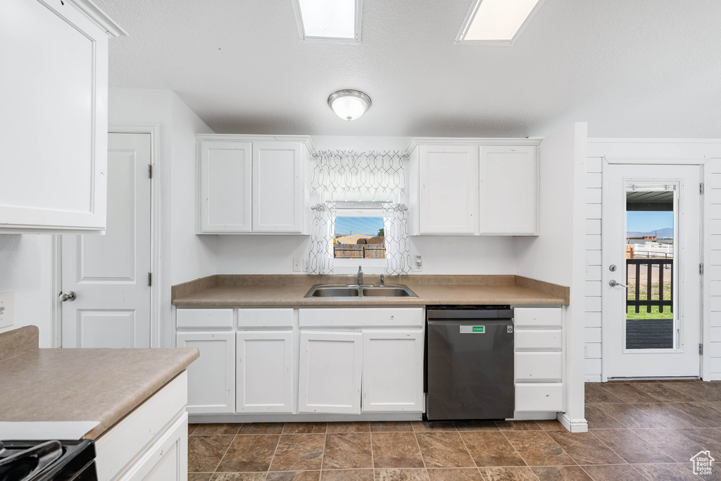 Kitchen featuring dishwasher, sink, and white cabinetry