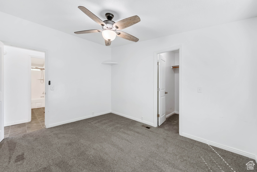 Carpeted empty room featuring ceiling fan