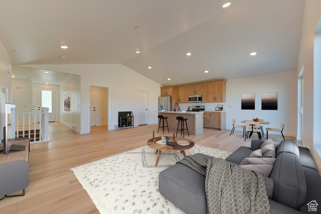 Living room featuring light wood-type flooring and vaulted ceiling