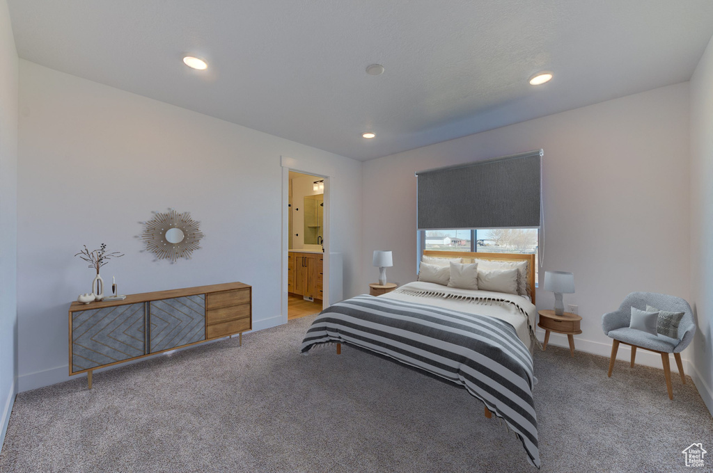 Bedroom with light carpet and connected bathroom