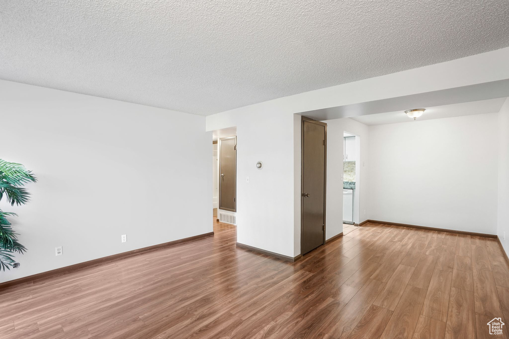 Spare room with wood-type flooring and a textured ceiling