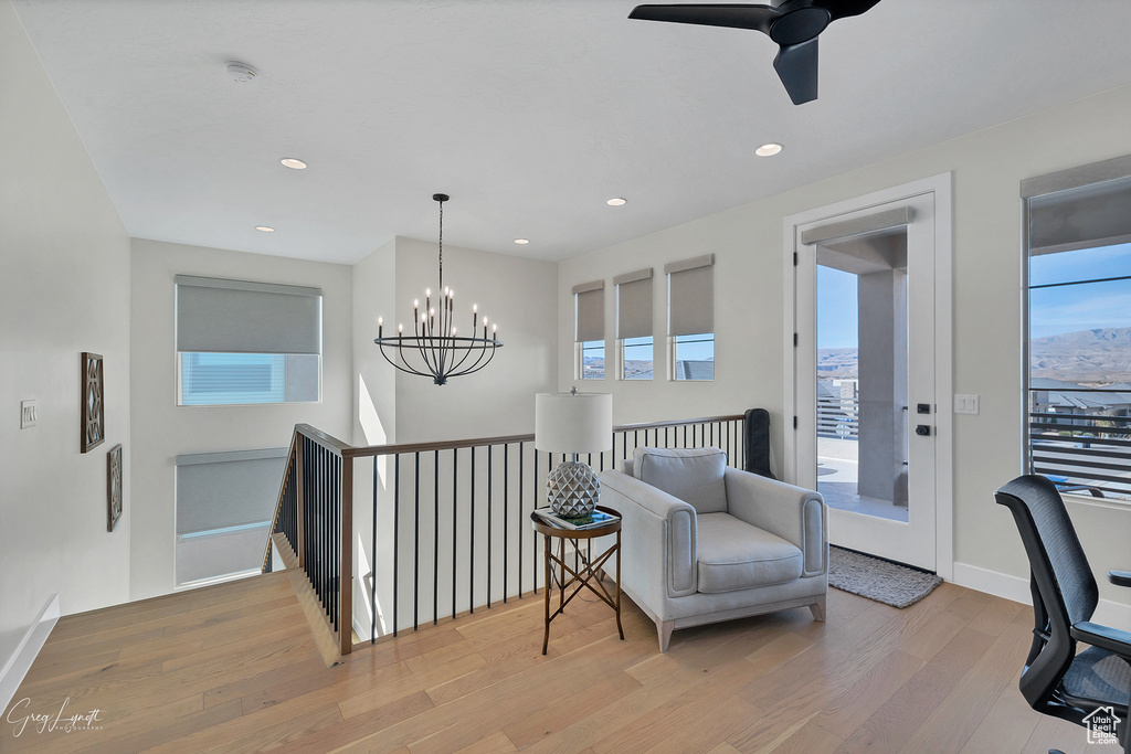 Sitting room featuring light hardwood / wood-style flooring and ceiling fan with notable chandelier