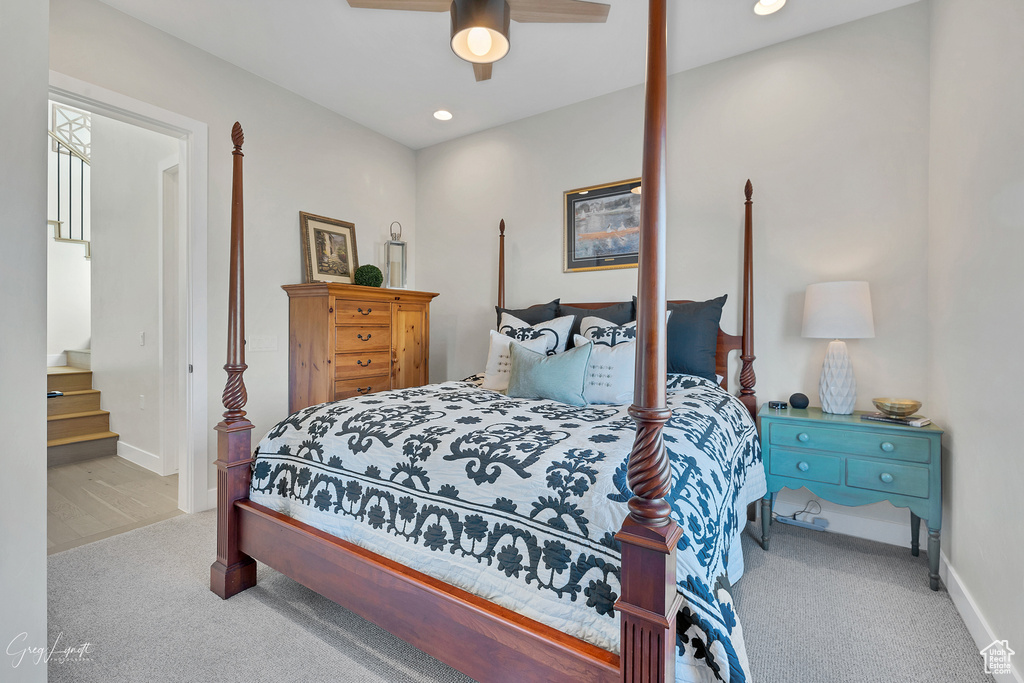 Carpeted bedroom with connected bathroom and ceiling fan