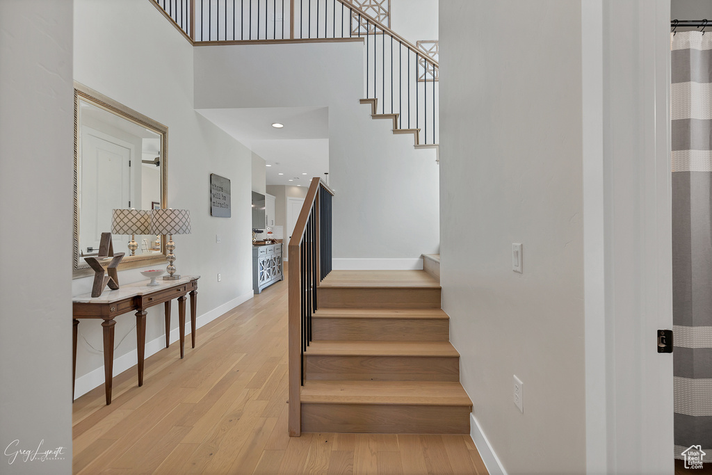 Stairway featuring wood-type flooring and a high ceiling