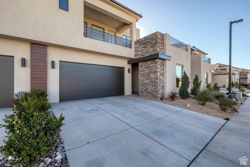 View of front of home featuring a balcony and a garage