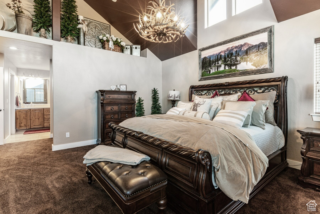 Bedroom featuring carpet floors, a notable chandelier, ensuite bathroom, and high vaulted ceiling