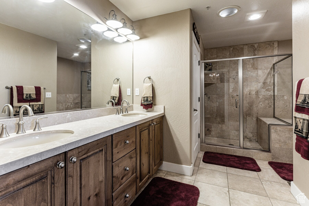 Bathroom featuring tile patterned flooring, an enclosed shower, and vanity