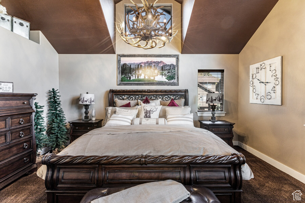 Carpeted bedroom with a chandelier and high vaulted ceiling