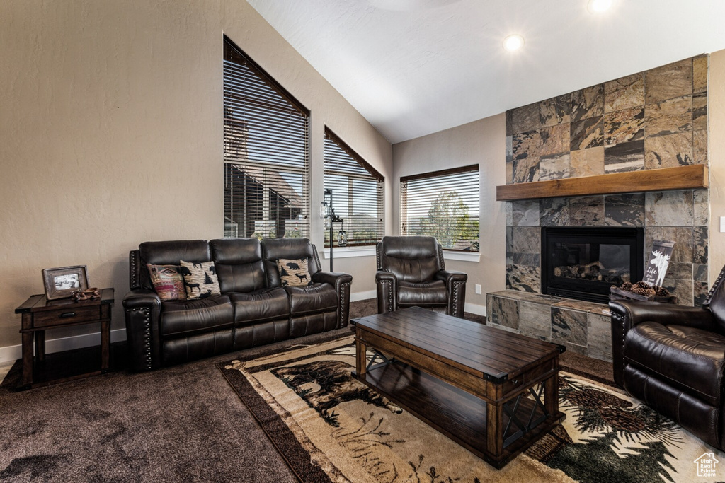 Living room featuring carpet floors, a fireplace, and lofted ceiling