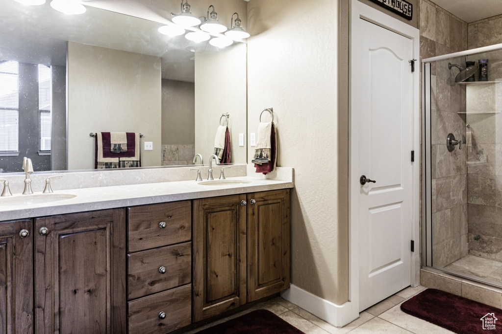 Bathroom with vanity, an enclosed shower, and tile patterned floors