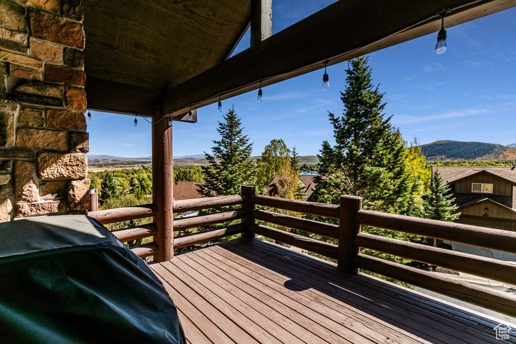 Wooden terrace featuring a mountain view and a grill