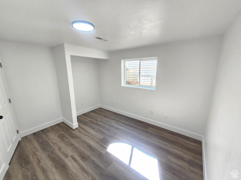 Unfurnished bedroom featuring dark hardwood / wood-style flooring