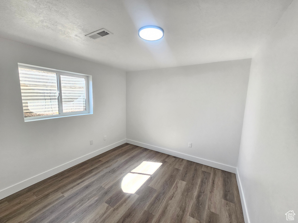 Spare room with dark wood-type flooring