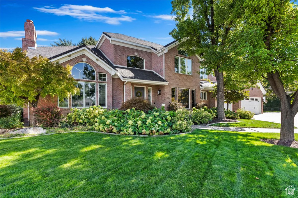 View of front of property featuring a front yard and a garage