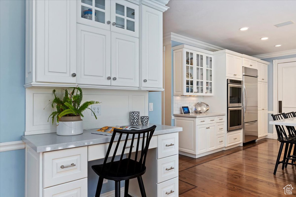 Kitchen with white cabinets, appliances with stainless steel finishes, and dark hardwood / wood-style floors