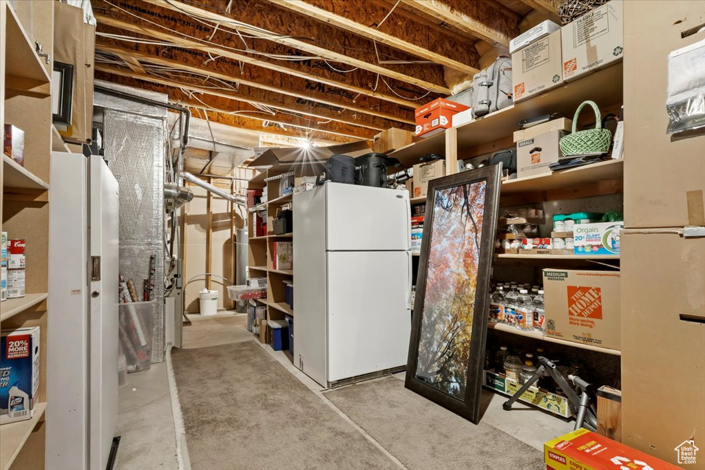 Basement featuring white refrigerator