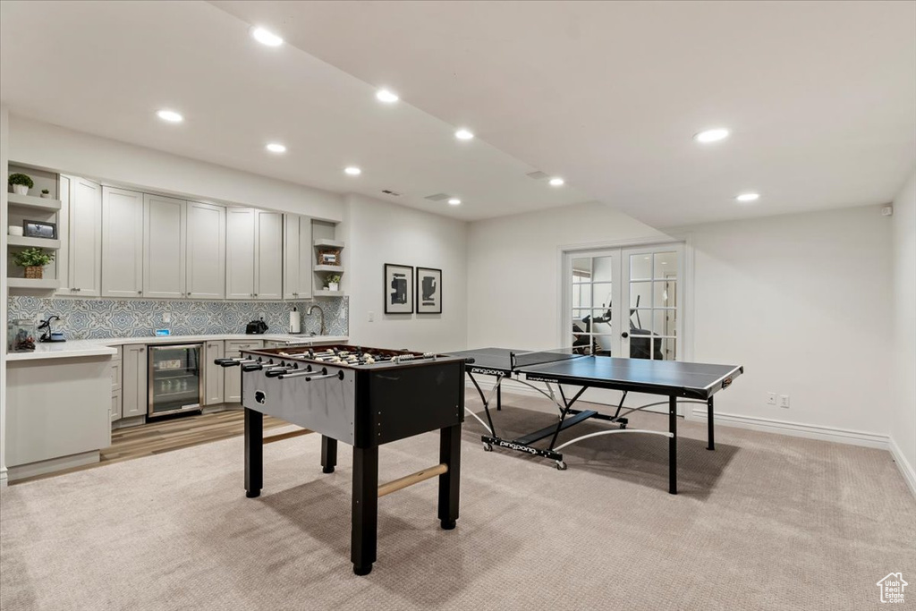 Playroom with light carpet, wine cooler, and french doors