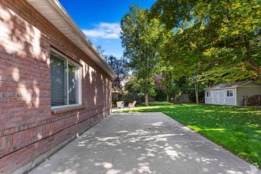 View of patio with a storage shed