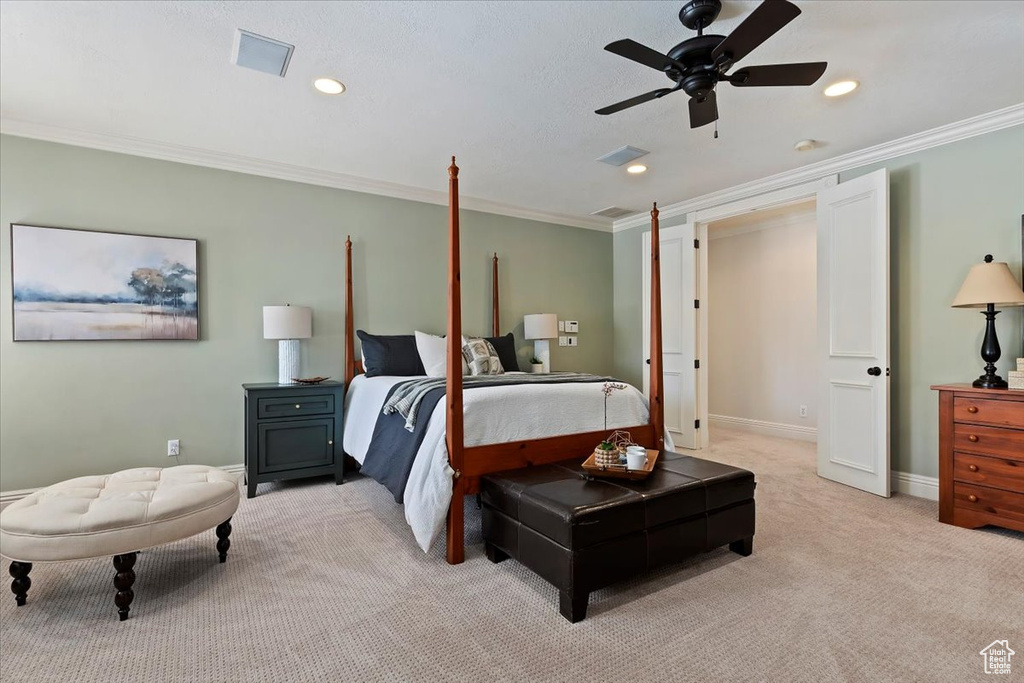 Carpeted bedroom featuring ornamental molding and ceiling fan