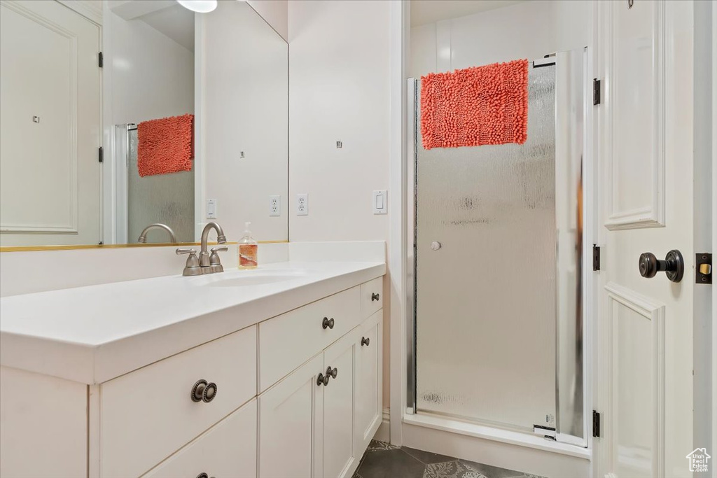 Bathroom with vanity, tile patterned flooring, and an enclosed shower