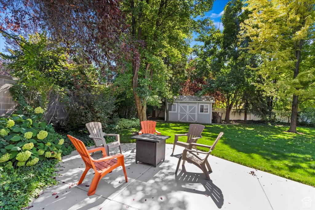 View of patio featuring a fire pit and a shed