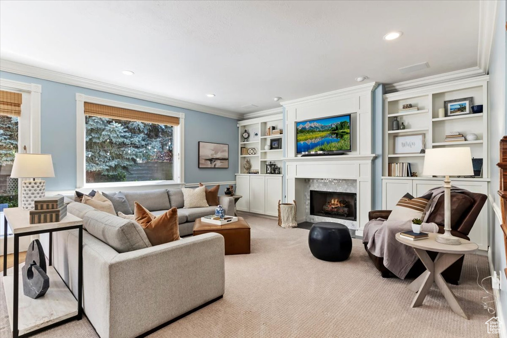 Living room with light carpet, a premium fireplace, and ornamental molding