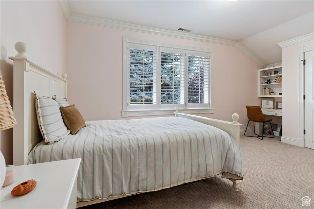 Bedroom with ornamental molding, lofted ceiling, and carpet floors