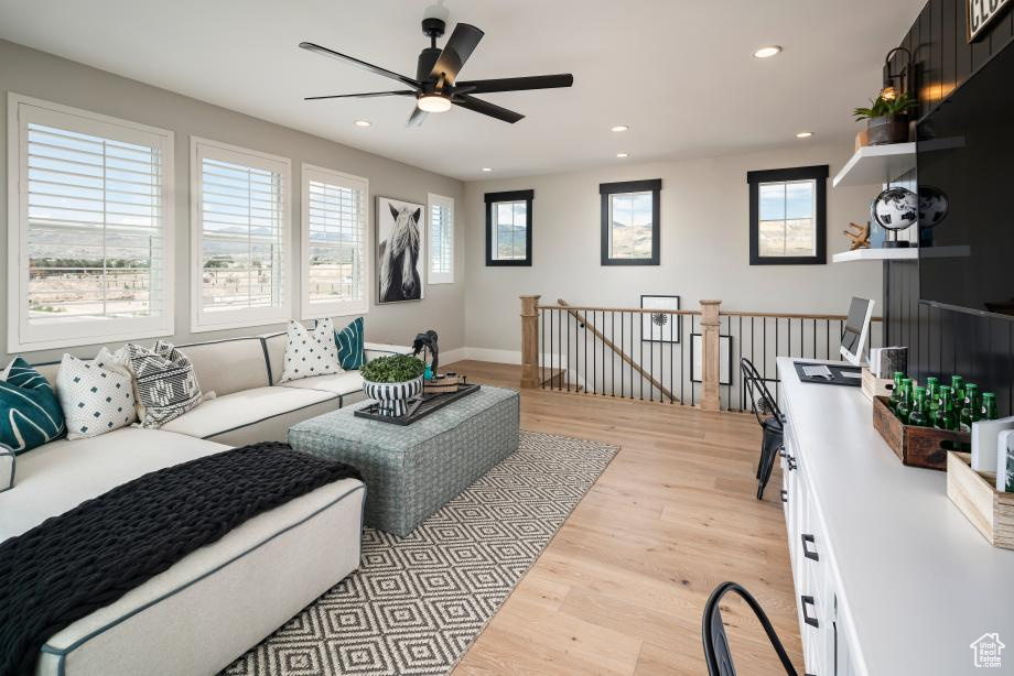 Living room featuring ceiling fan and light hardwood / wood-style flooring