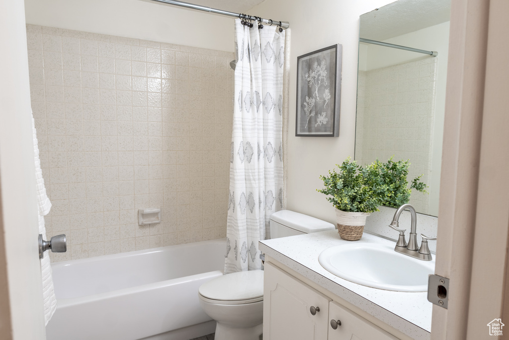 Full bathroom with shower / bath combo, vanity, and toilet