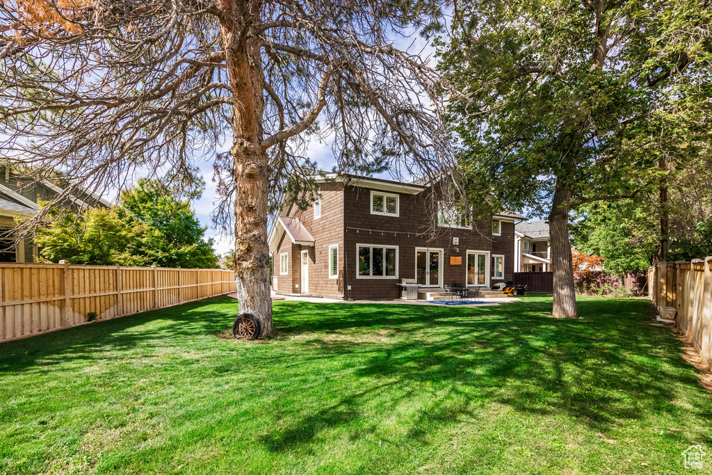 Back of house with a lawn and a patio area