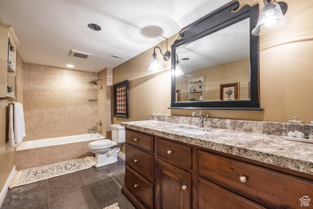 Full bathroom with vanity, tiled shower / bath, and toilet