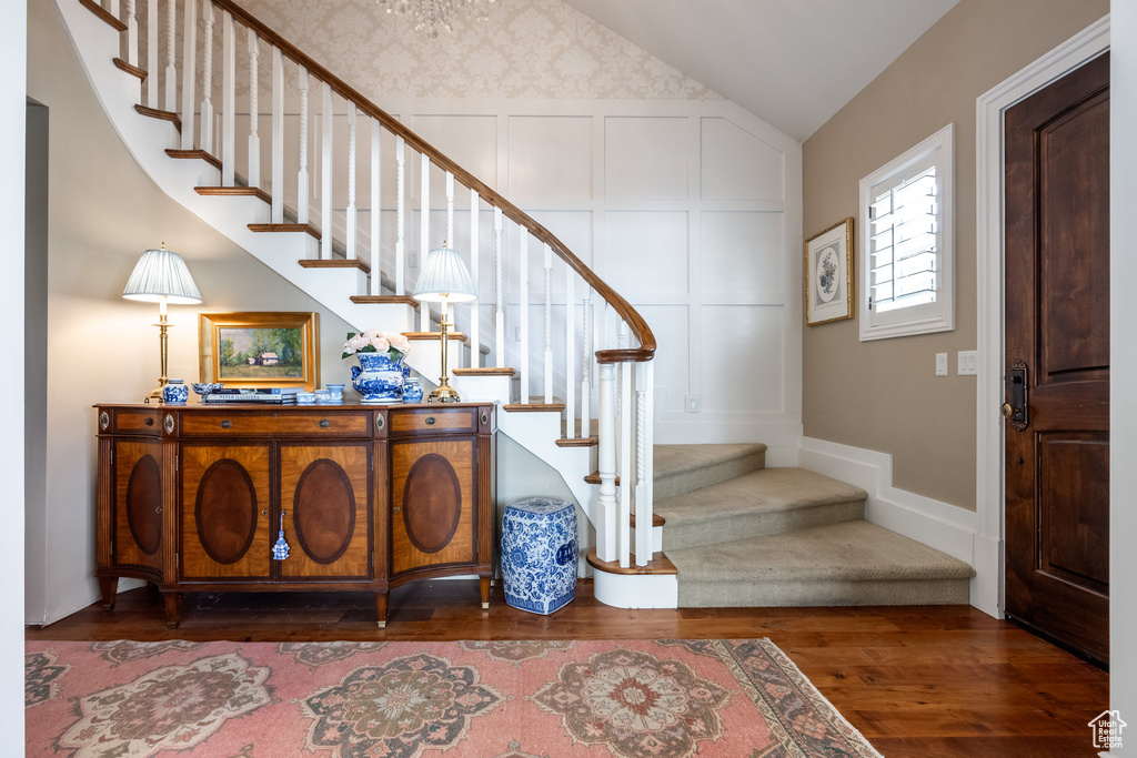 Stairs featuring lofted ceiling and hardwood / wood-style floors