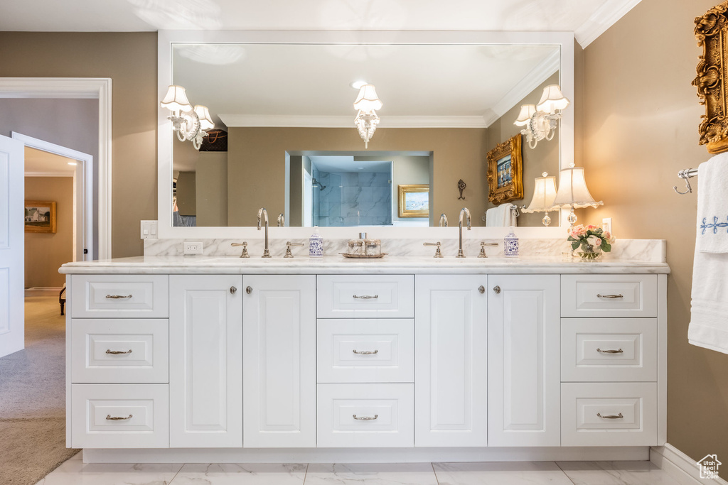 Bathroom featuring walk in shower, vanity, and crown molding