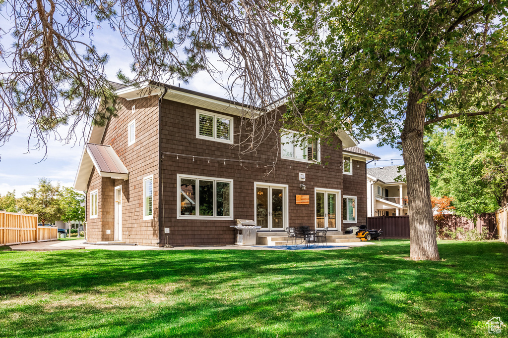 Rear view of property with a yard and a patio