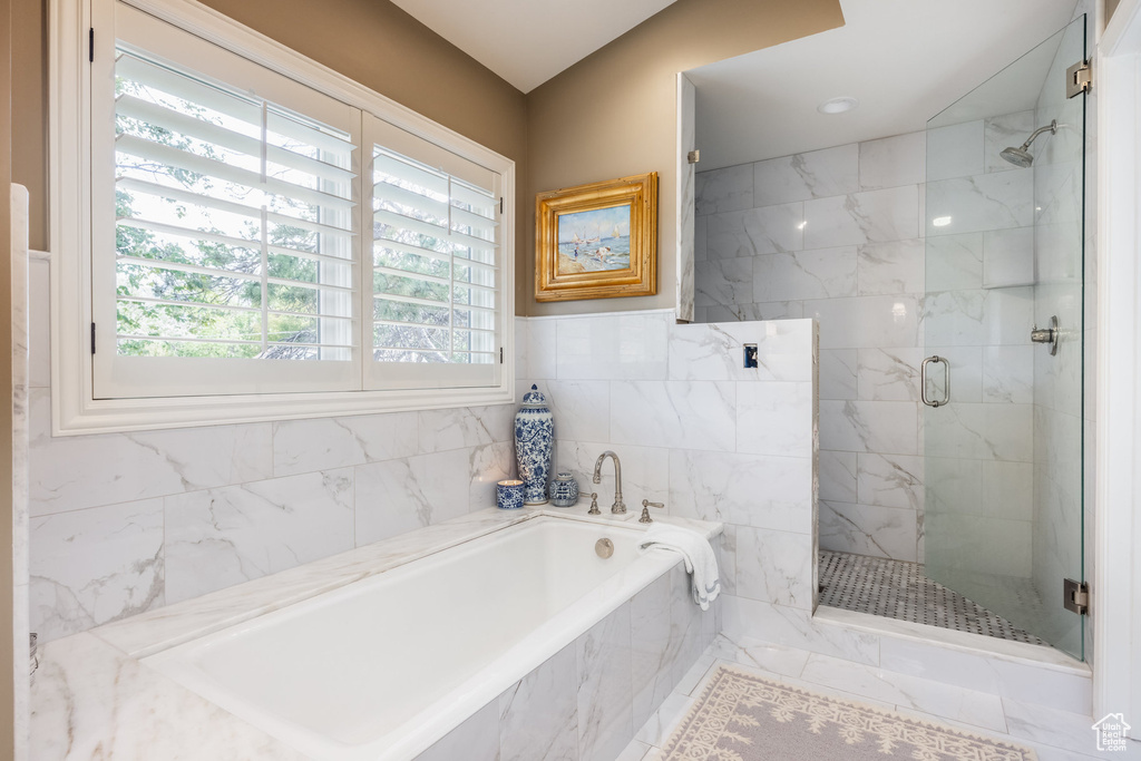 Bathroom with tile walls and independent shower and bath